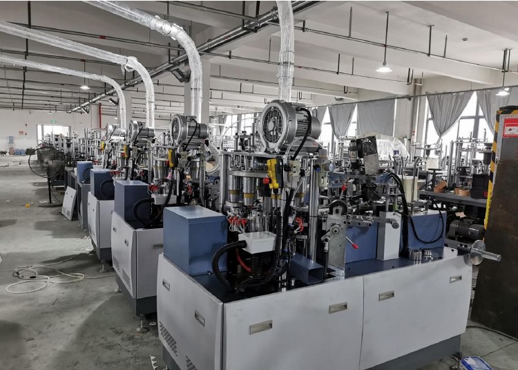 Paper cup machines in a workshop for new and used equipment comparison
